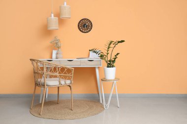 Çalışma odasının yanındaki turuncu duvardaki saat.