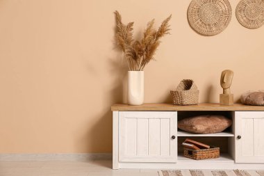 Oturma odasının içinde, kahverengi duvarın yanında klozet var.