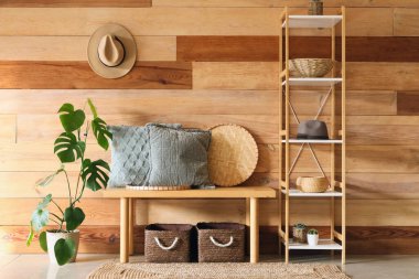 Yastıklı bank ve koridorun iç tarafında raf ünitesi.