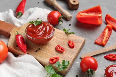 Lezzetli ketçaplı kompozisyon ve gri grunge arka planda malzemeler.