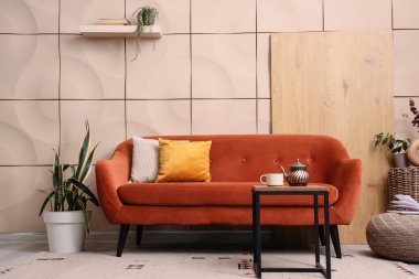 Kanepesi, masası ve bitkileri olan şık bir oturma odası.