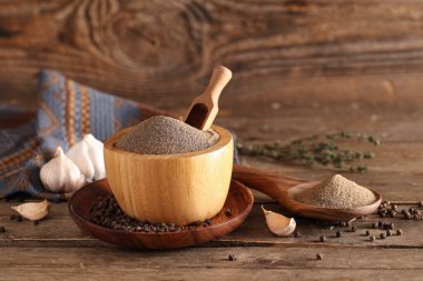 Karabiber tozu, sarımsak ve ahşap zemin üzerinde biber dolu bir kâse.