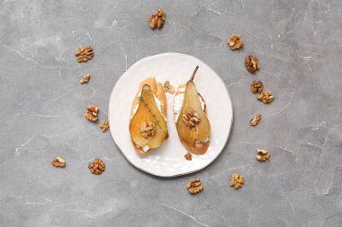 Armut bruschetta tabağı, ricotta peyniri ve fındıklı gri arka plan.