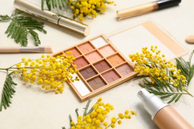 Dekoratif kozmetik ürünleri ve beyaz arka planda mimoza çiçekleri, yakın plan