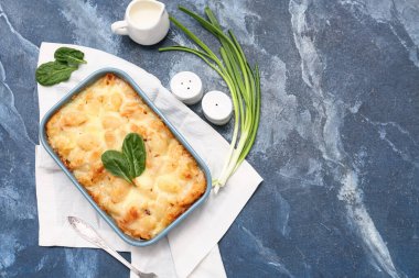 Lezzetli makarna, ıspanak yaprakları, yeşil soğan ve mavi grunge arka planda bir sürahi sütle pişirme yemeği.