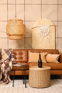 Rahat bir kanepe, kahve masası ve şişesi oturma odasının içinde.