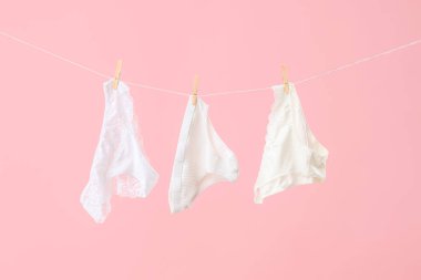 Çamaşır ipinde pembe arka planda asılı kadın külotu