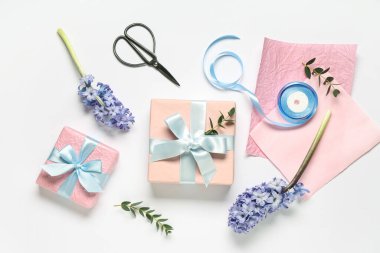 Çiçekli hediye kutuları, beyaz arka planda ambalaj kağıdı ve makas. Uluslararası Kadınlar Günü