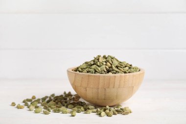 Beyaz ahşap arka planda kakule baharatlı kase.