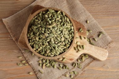 Tahta arka planda kakule baharatlı kase ve yemek.