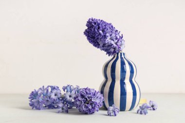 Beyaz arka planda güzel mor sümbül çiçekleri olan vazo