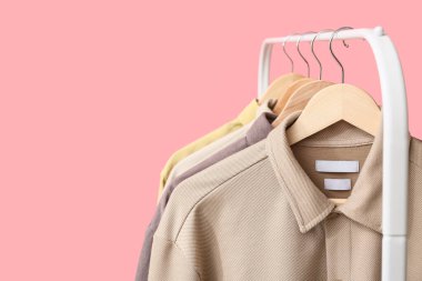 Pembe arka planda şık yakalı gömlekler, yakın plan.