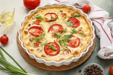 Arkaplanda roka yapraklı lezzetli domates turtası, biber ve yeşil soğan, yakın plan.