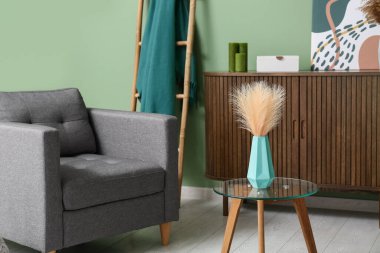 Oturma odasının iç tarafındaki masada kuru kamışlı nane vazosu.