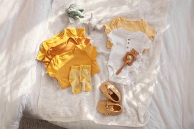 Bebek kıyafetleri, ayakkabılar ve oyuncaklar odada, üst tarafta.