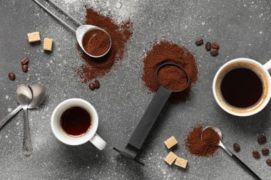 Kahve tozu ve kahve fincanları gri grunge arka planda, yakın plan.