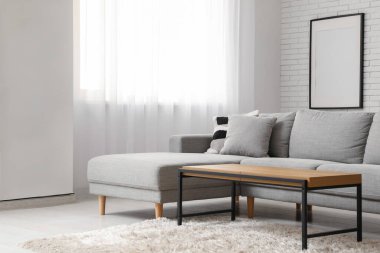 Oturma odasının penceresinin yanındaki masa ve kanepe.