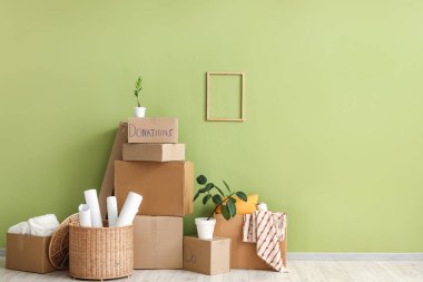 Odadaki yeşil duvarın yakınındaki bağışlar için karton kutular.