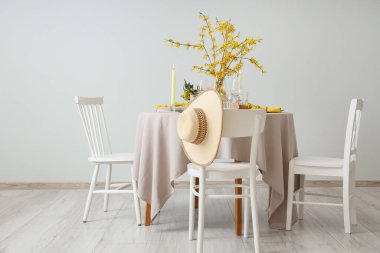 Yanan mumlar, bardaklar ve çiçek açan ağaç dalları olan zarif bir masa.