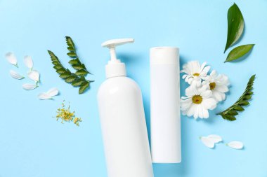 Mavi arka planda duş jeli, çiçek, yeşil yapraklar ve taç yaprakları olan kompozisyon