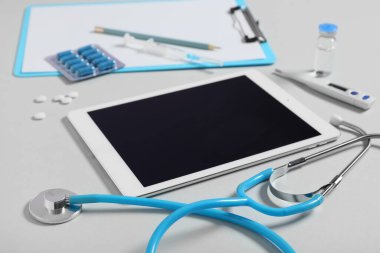 Açık arkaplanda doktor malzemeleri olan boş tablet bilgisayar, kapat