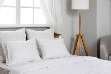 Yatak ve lambada beyaz çarşaf olan odanın içinde.