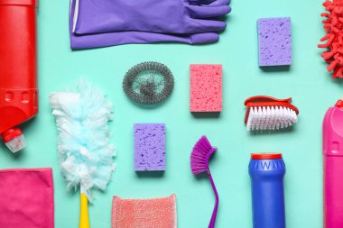 Renk arkaplanında farklı temizlik malzemeleri ve deterjanları olan kompozisyon