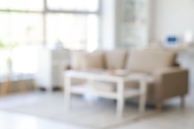 Yumuşak kanepe, masa ve pencereli oturma odasının bulanık görüntüsü