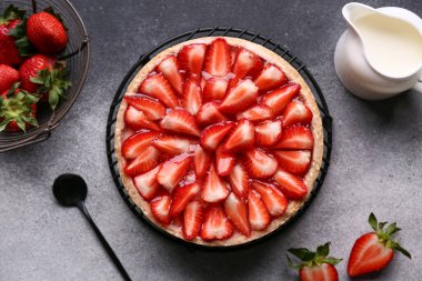 Tatlı çilekli turta ve bir sürahi taze sütle dikil.