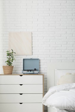 Konforlu yatak odası ve retro müzik çaları şifoniyerde.