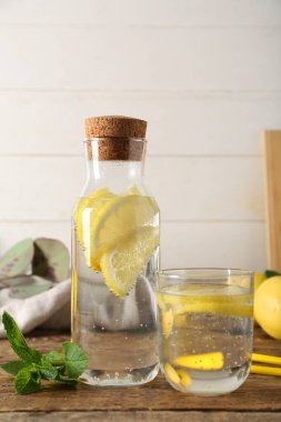 Bardak ve bir şişe taze limonata ve ahşap masada nane şekeri.