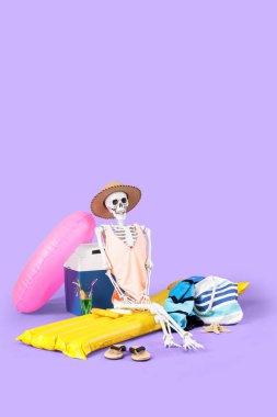 Leylak arka planında plaj aksesuarları olan insan iskeleti. Yaz tatili kavramı