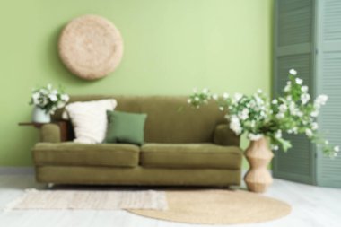 Oturma odası, kanepe ve yasemin çiçekli vazolar.