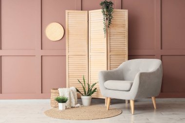 Gri koltuklu, katlanır perdeli ve bitkilerli şık bir oturma odası.