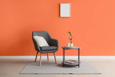 Koltuğu, masası ve boş çerçevesi olan şık bir oturma odası.