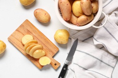 Ahşap tahta ve arka planda çiğ bebek patatesli süzgeç.