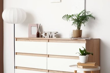 Çekmeceler, masa ve zemin lambası, odanın içindeki beyaz duvarın yanında, yakın plan.