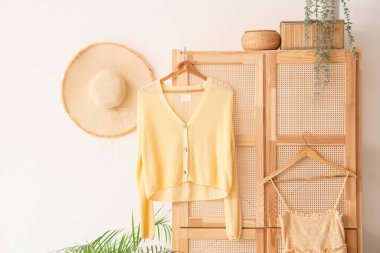 Odanın ahşap dolabında asılı şık kıyafetler.