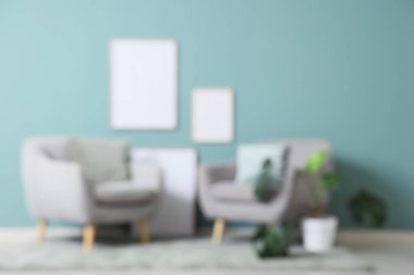 Koltukları, fotoğraf çerçeveleri ve çiçekleri olan bulanık oturma odası manzarası