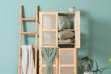 Ahşap dolap ve merdiven, oturma odasındaki nane duvarının yanında, yakın plan.