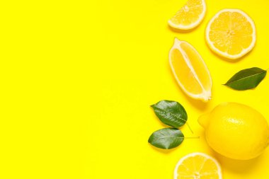 Taze olgun limonlar ve sarı arka planda yapraklar