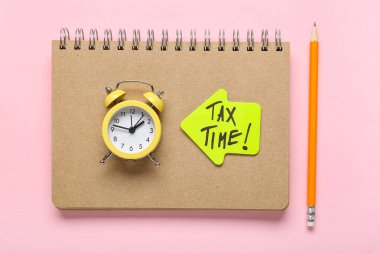 Not defteri, alarm saati ve okun üzerinde pembe arkaplan üzerinde vergilendirme zamanı