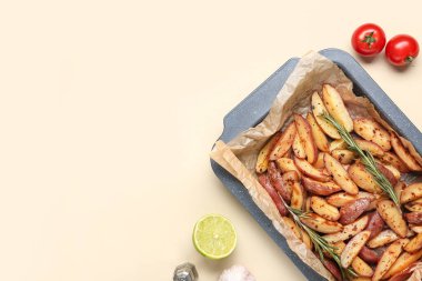 Lezzetli fırında patates ve bej arka planda taze sebze tepsisi, yakın plan.