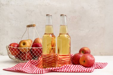 Taze elma şarabı şişeleri ve beyaz arka planda meyveler