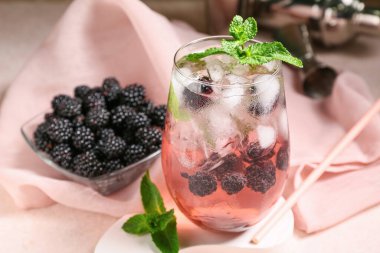 Lezzetli böğürtlenli limonata ve bej grunge arka planda sıva podyumu, yakın plan.