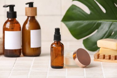 Bej kaplama arka planında kavanoz ve bir şişe kozmetik ürünü içeren spa kompozisyonu, yakın plan