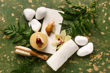 Spa aksesuarları, dev Achatina salyangozları ve eğreltiotu yapraklarıyla renklendirilmiş grunge arkaplanı.