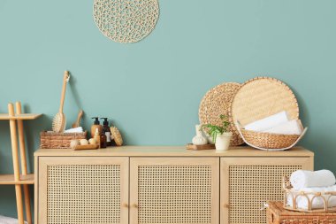 Hasır sepetler, masaj vücut fırçaları, ahşap toplar ve çekmecelerin üstündeki kozmetik ürünler, yakın plan.