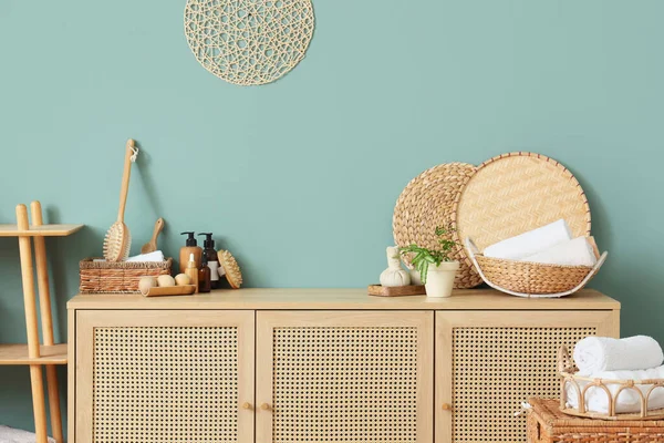 Hasır sepetler, masaj vücut fırçaları, ahşap toplar ve çekmecelerin üstündeki kozmetik ürünler, yakın plan.