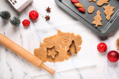 Zencefilli kurabiye tepsisi, kesiciler, merdane ve grunge beyaz arka planda Noel süslemeleri.